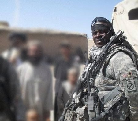 William in combat gear with Afghan villagers, faces of others blurred.