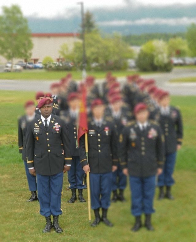 William at the front of a formation in dress uniform and maroon beret.